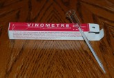 A vinometer is a piece of apparatus that consists of an open, graduated glass tube with a small filling resevoir.

The vinometer's reservoir or funnel is filled with a small amount of wine being tested until some wine exits out at the other end.